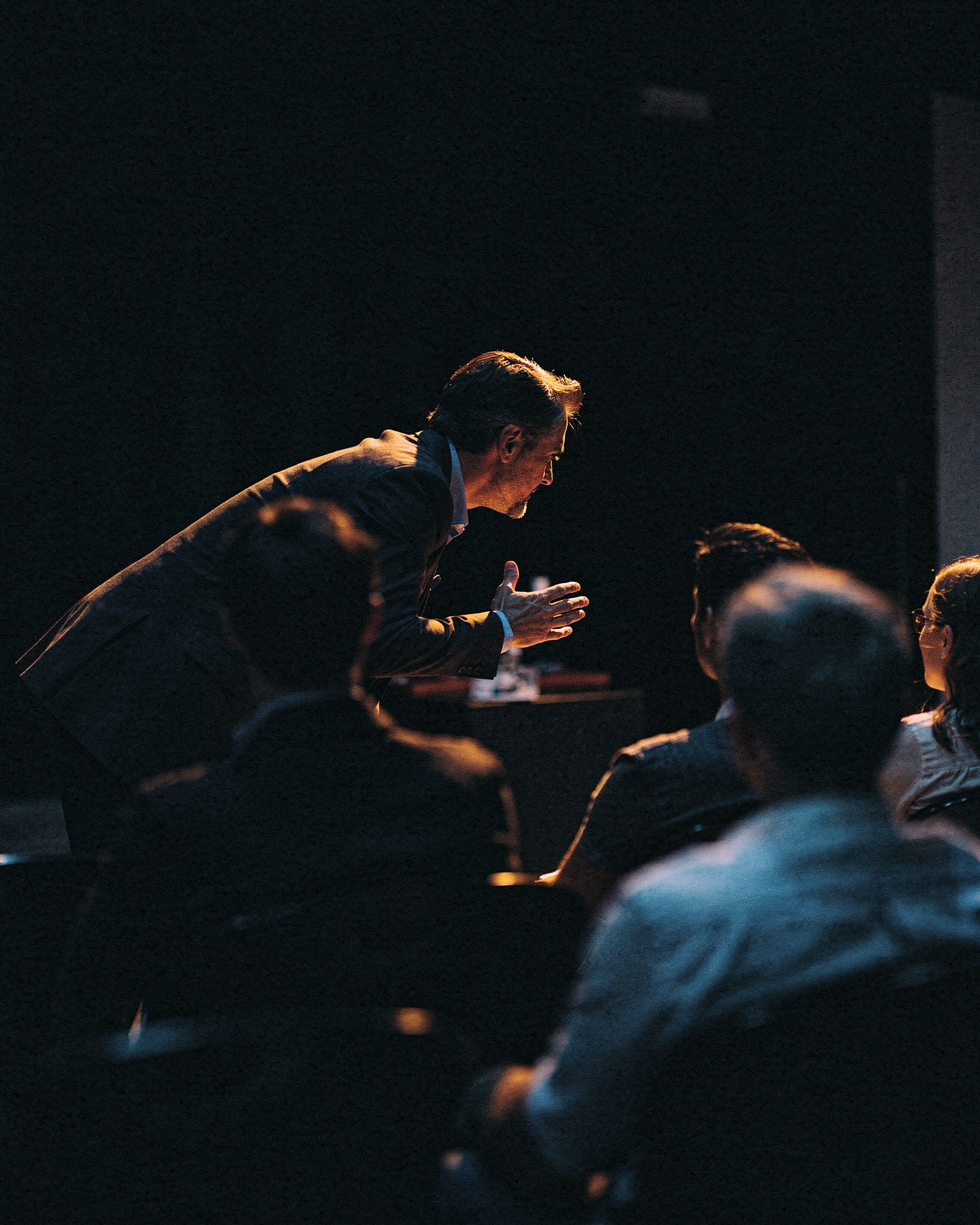 Speakers & Coaches at work, photographed in dark studio light